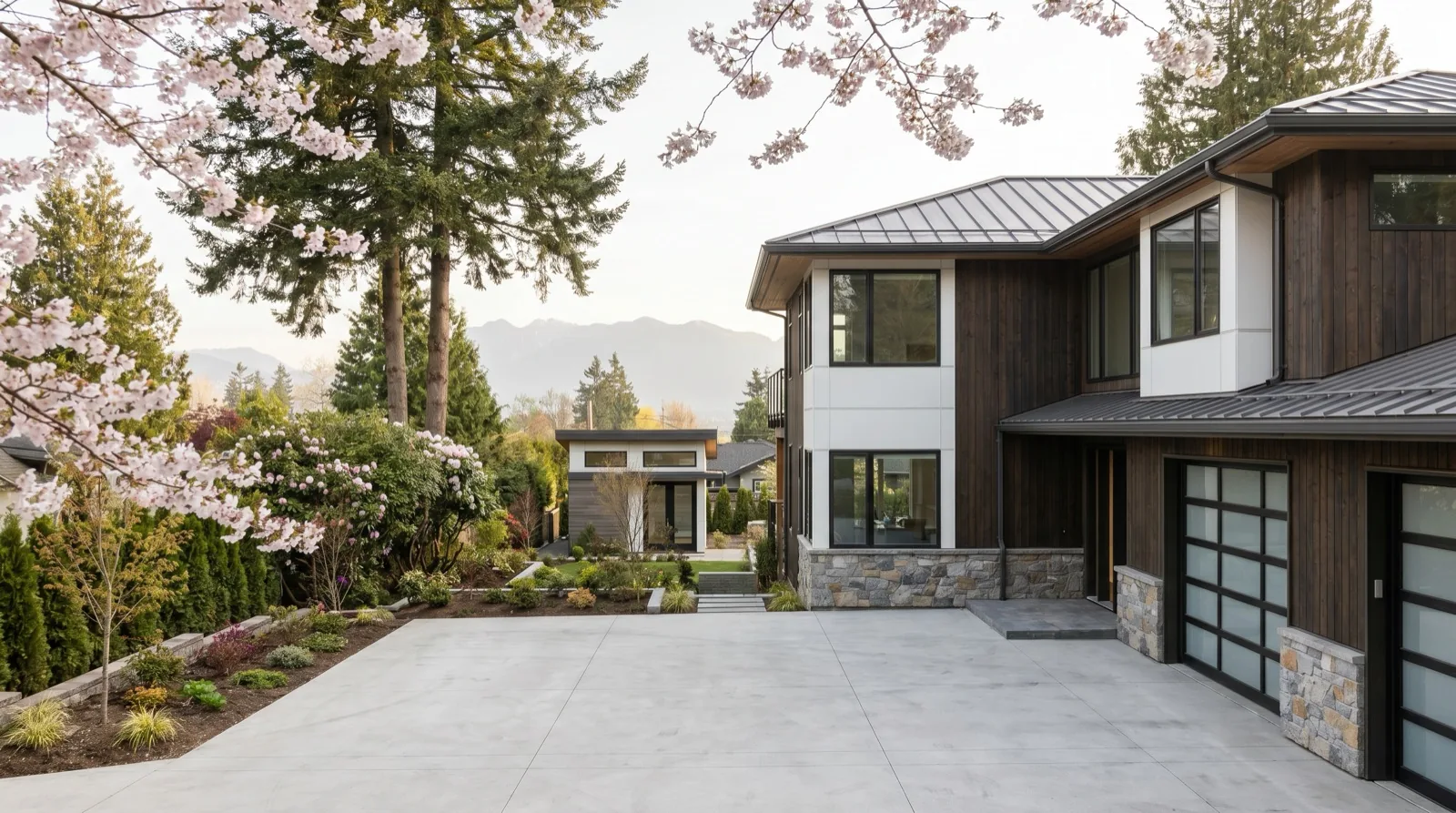 Burnaby BC residential street in Buckingham Heights neighbourhood with a newly built modern custom single family home on a large lot with mature trees and mountain views in the background representing why SFH construction still pencils on premium Burnaby lots in 2026