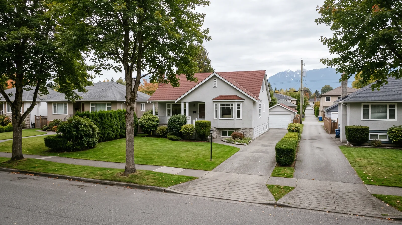 An older detached single-family house on a wide Vancouver lot with lane access and mature trees, the kind of ordinary property a multiplex buyer now evaluates for redevelopment potential