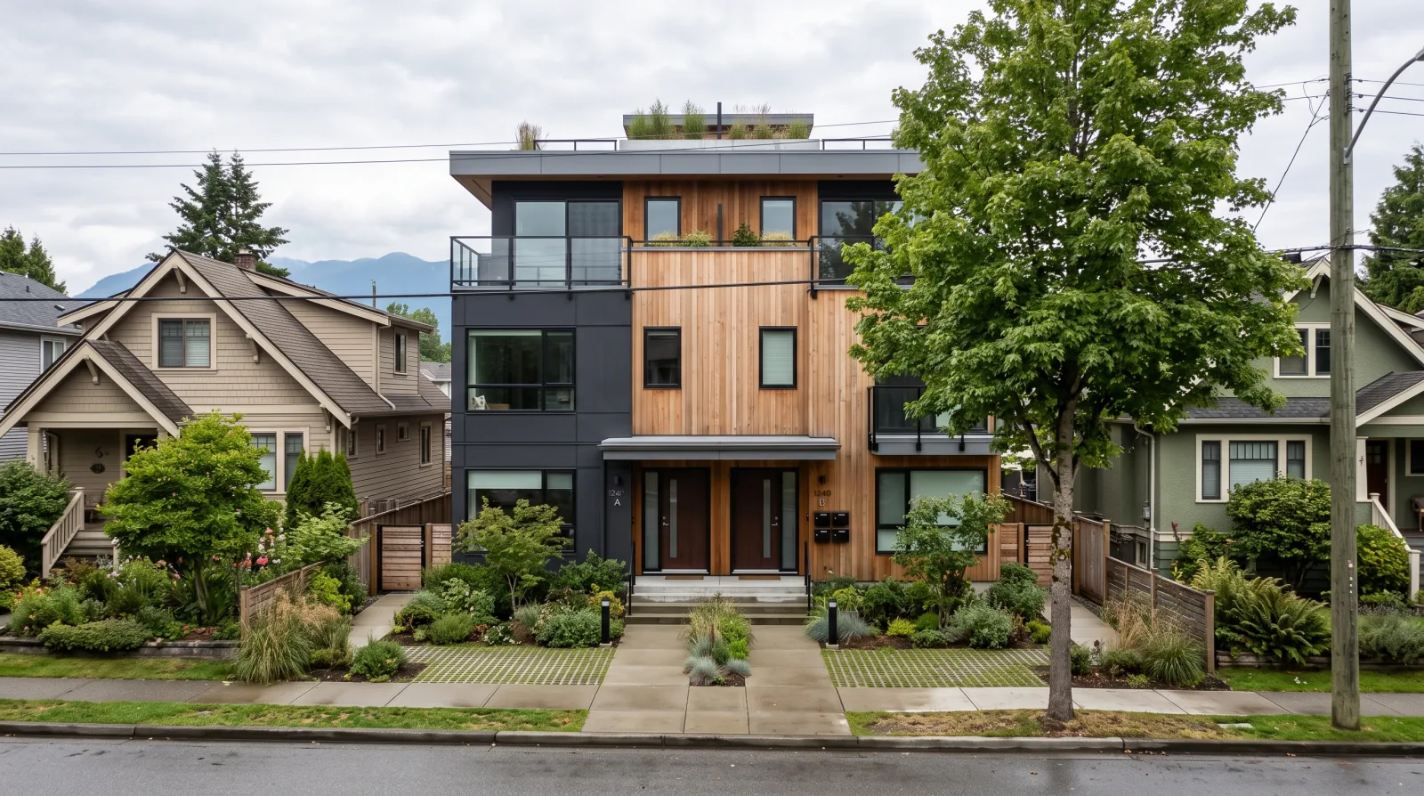 A newly built three-storey ground-oriented multiplex with two front doors on a Vancouver residential street between older single-family houses, the incremental owner-built density that survives after Council rejected the Villages Plan